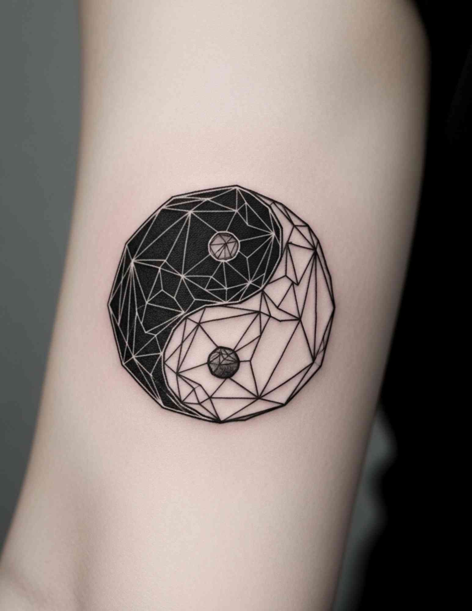 Geometric yin yang tattoo built from angular facets and repeating linework