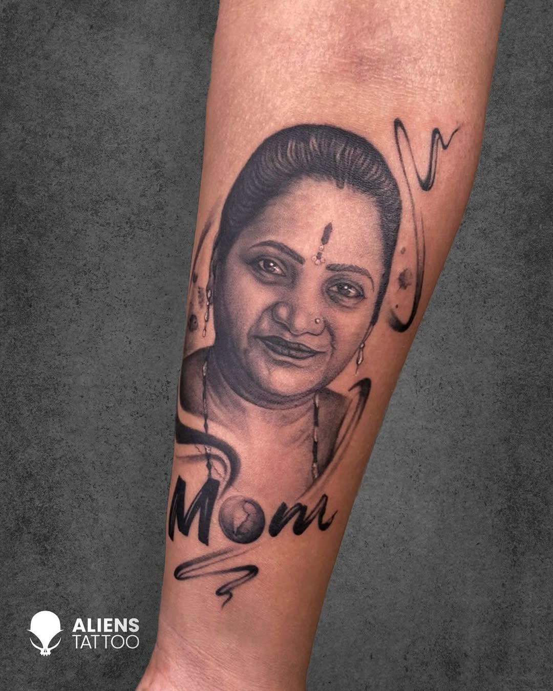 Black and grey portrait memorial tattoo for mom with soft realistic shading.
