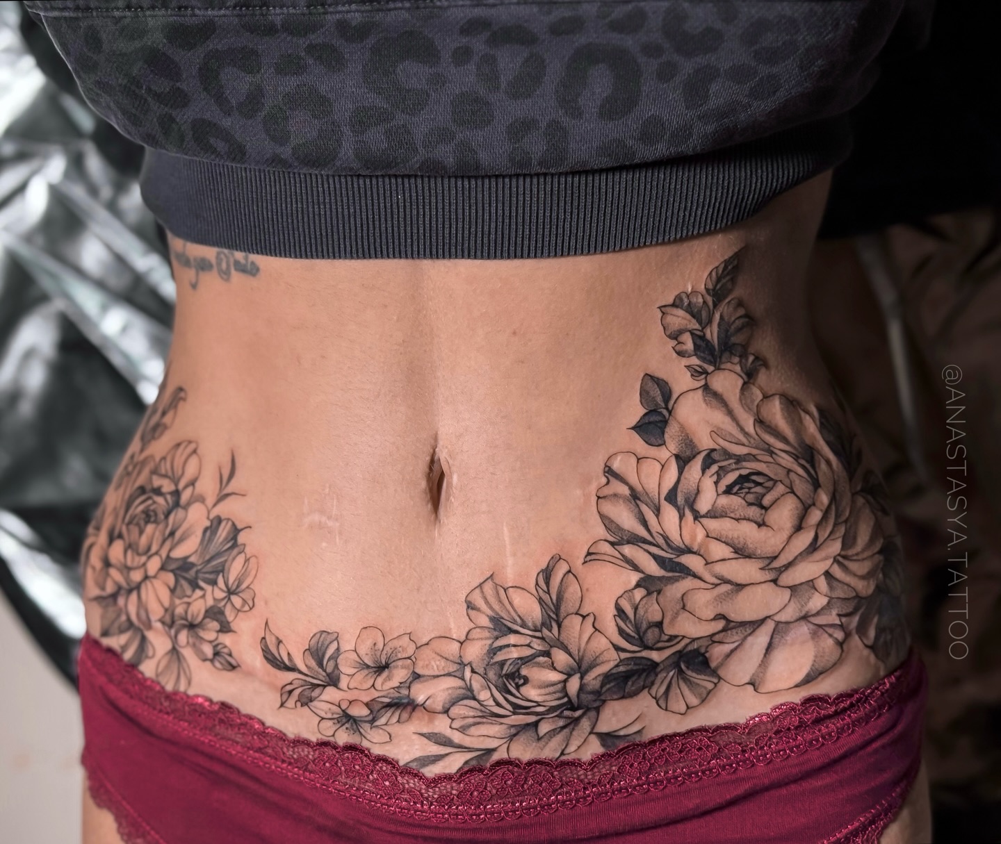 Floral tattoo over a surgical scar, with blooms growing along the incision line
