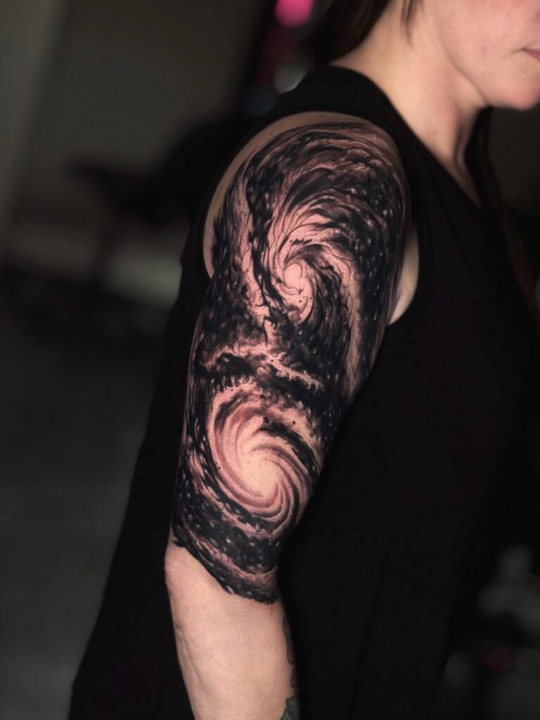 Galaxy swirl space tattoo with spiral arms in soft blue and violet washes