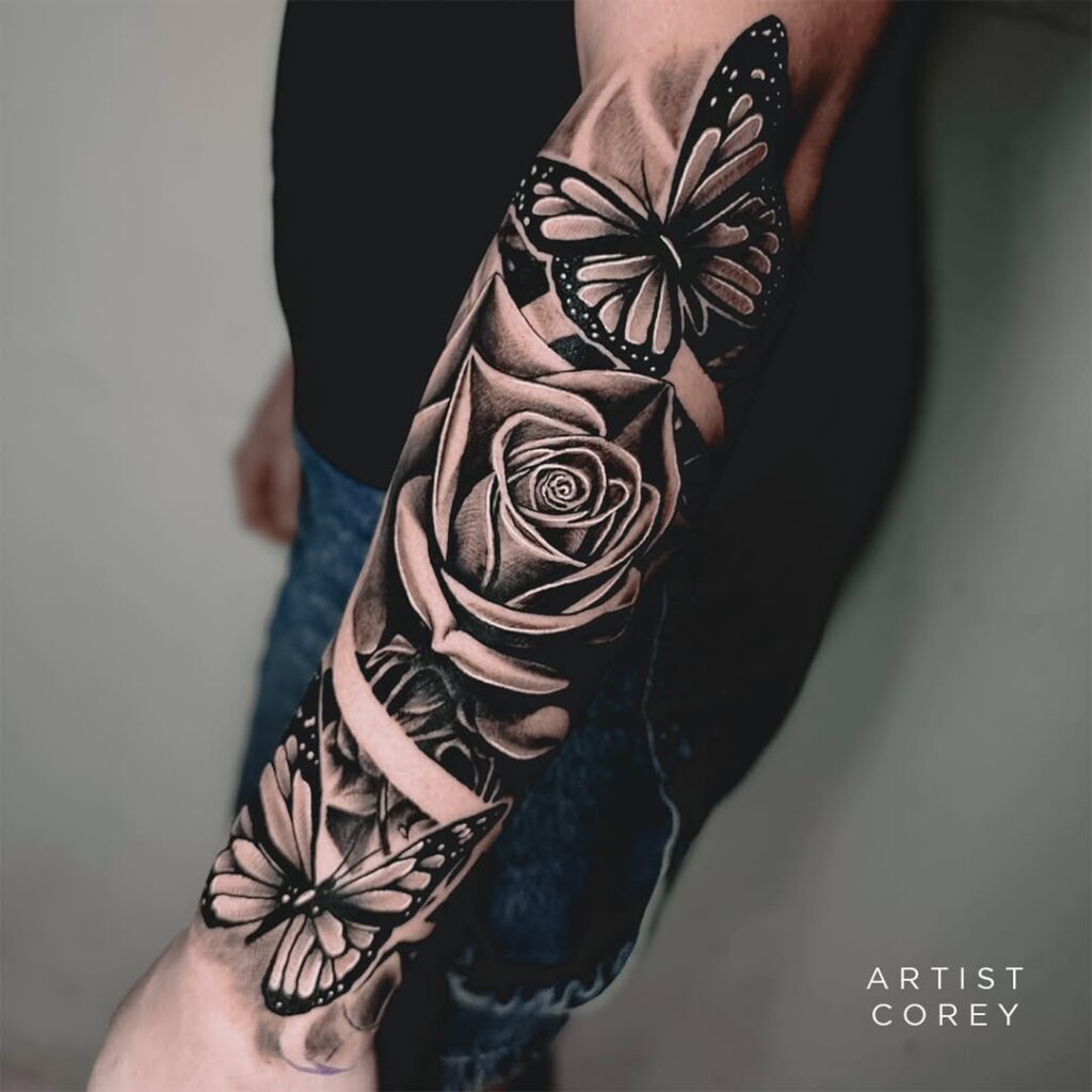 Rose and butterfly sleeve tattoo with butterflies resting between colour blooms