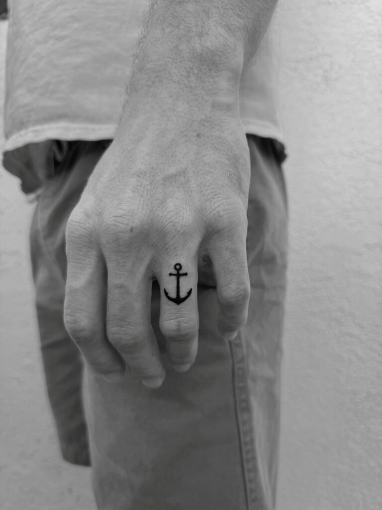 Small anchor tattoo for men in fine line blackwork, a classic small meaningful tattoo design
