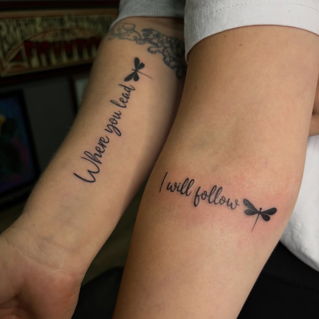 Interlocking puzzle piece mother son tattoo in solid black linework
