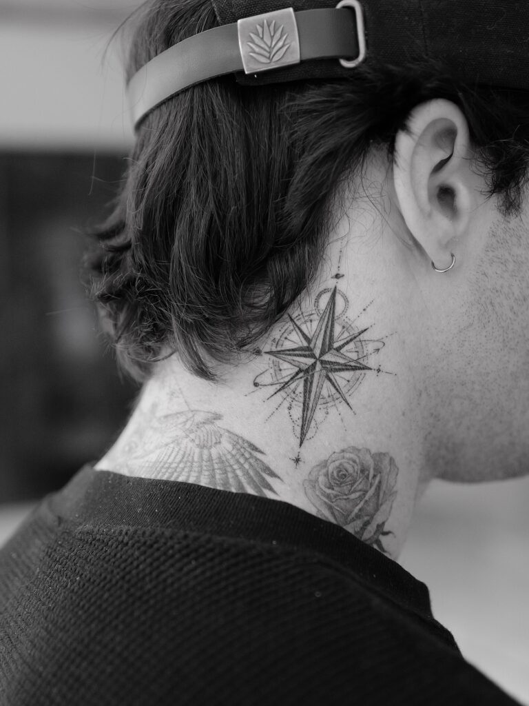 Small compass rose tattoo for men in minimal fine line style, a meaningful direction symbol