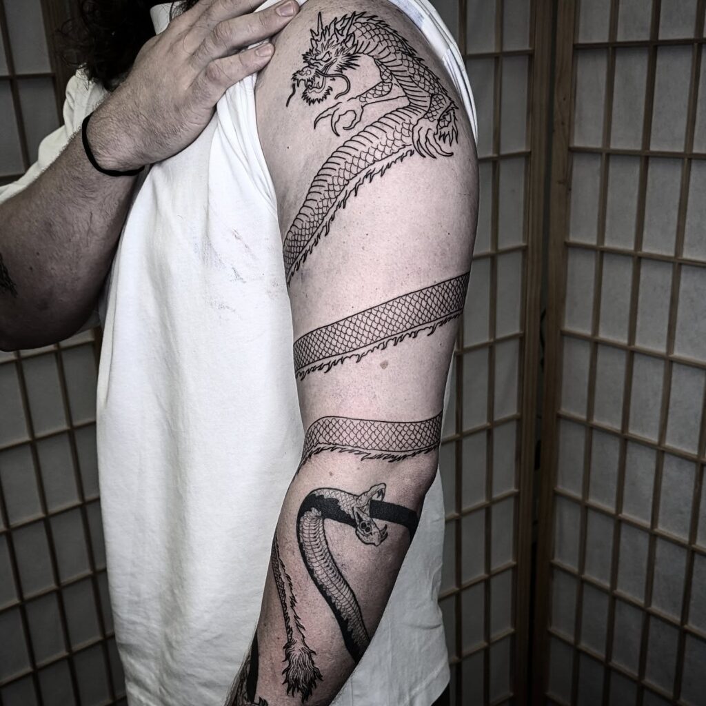 Dragon tattoo for women wrapped around the upper arm so the body follows the muscle