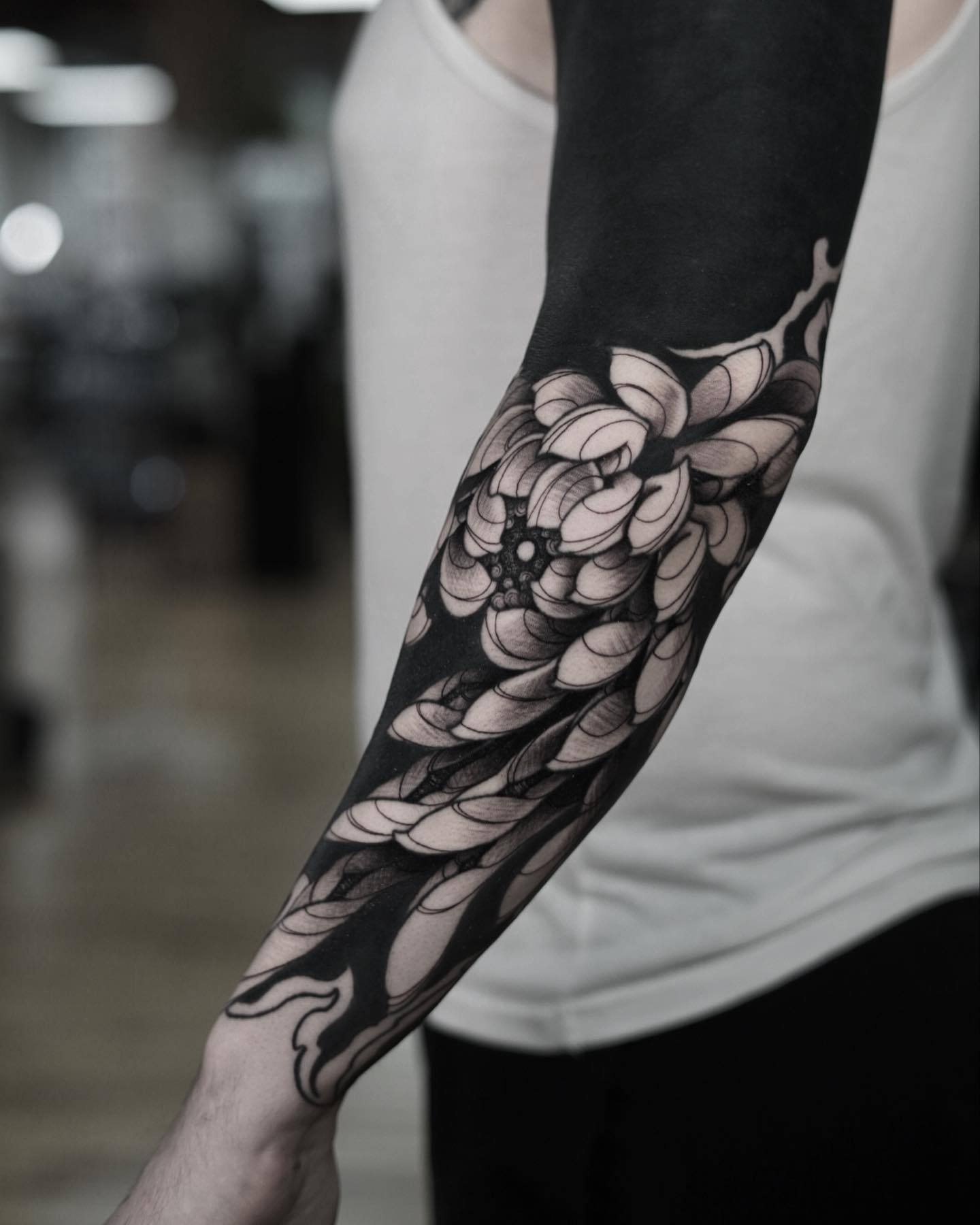 Full blackout cover up tattoo covering the forearm in solid black after previous tattoos were removed from view.