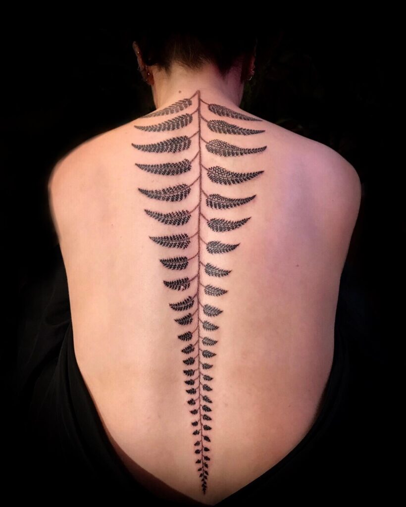 Fern spine tattoo running vertically down the centre of the back