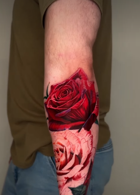 Colour realism rose sleeve tattoo with botanically accurate petals in deep red and cream