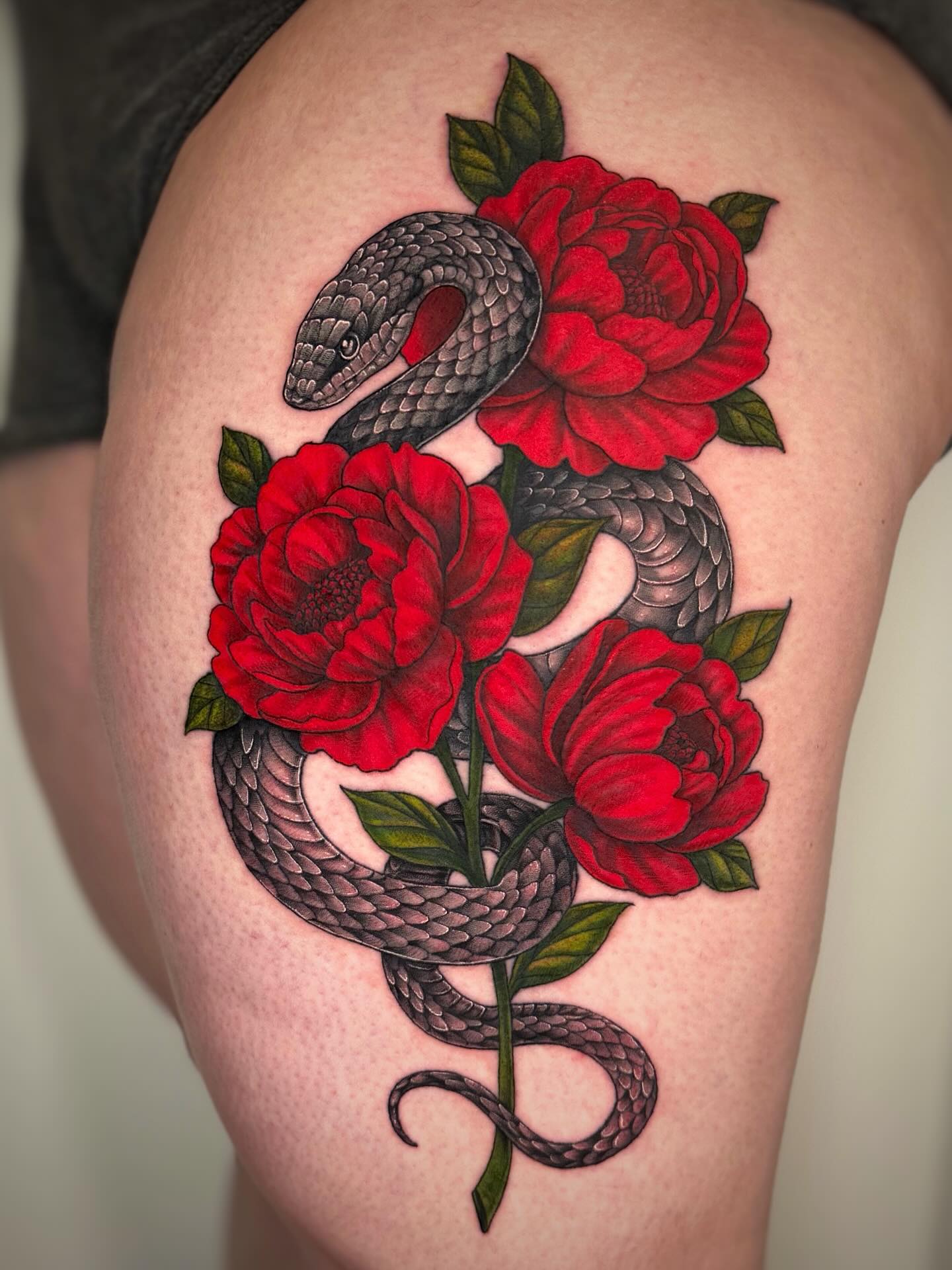 Peony and snake tattoo for women with the snake coiling through the flower stems