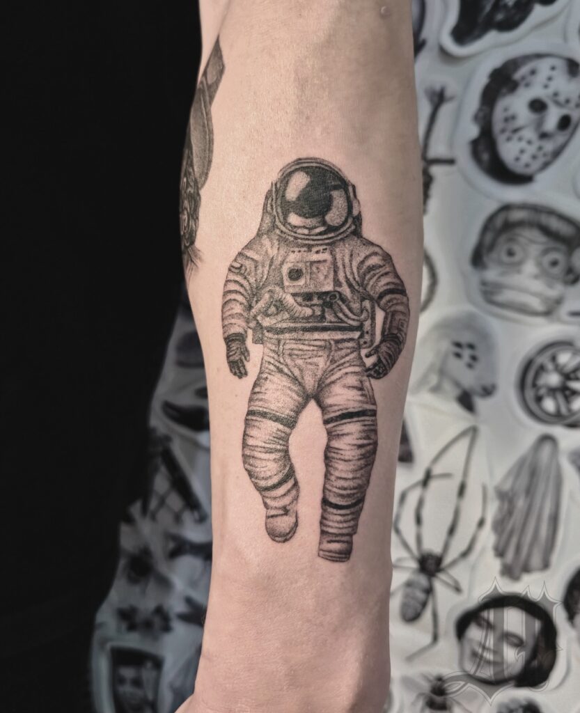 Astronaut space tattoo of a suited figure floating against a starfield
