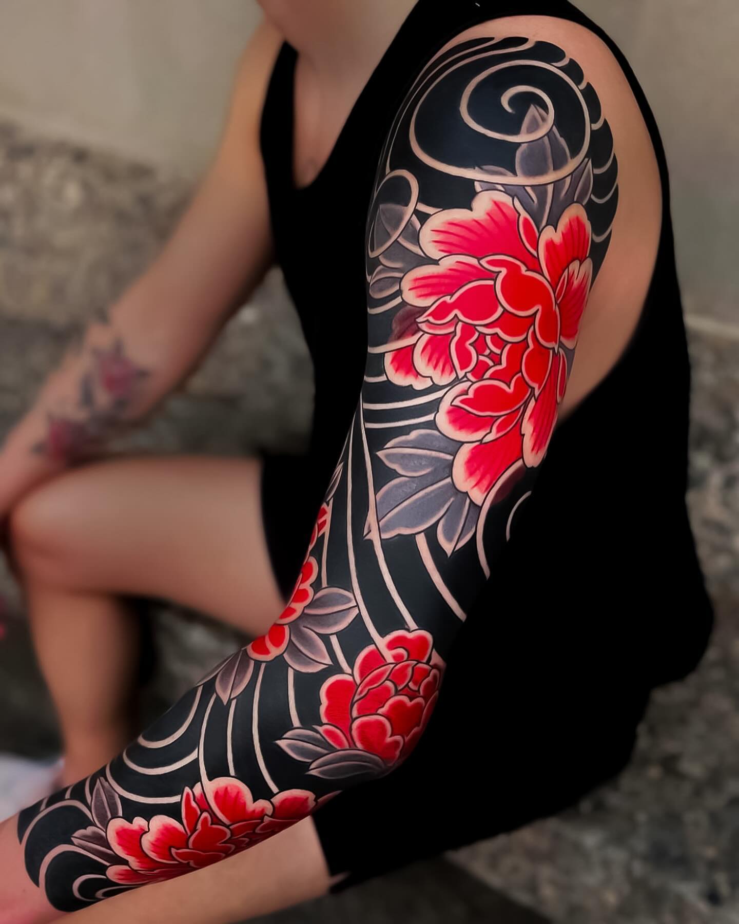 Full black and red tattoo sleeve combining multiple subjects in a two-colour palette