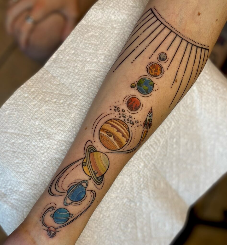 Solar system space tattoo with the planets lined up in order in fine line work