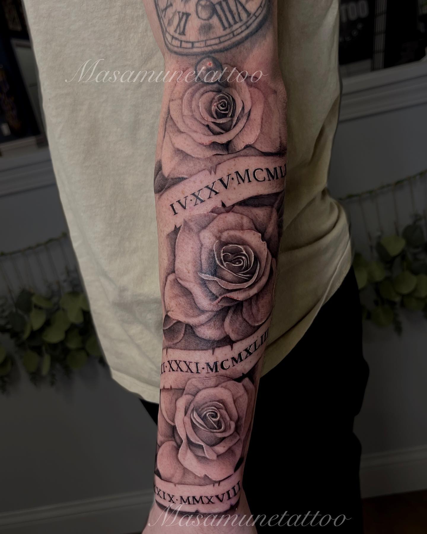 Traditional rose and banner sleeve tattoo with lettered scrolls woven around the flowers