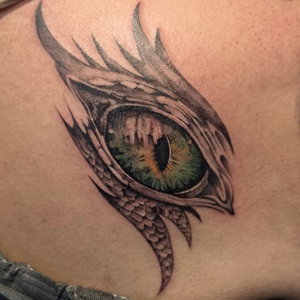 Dragon eye tattoo for women rendered in close-up detail with layered scales around the iris
