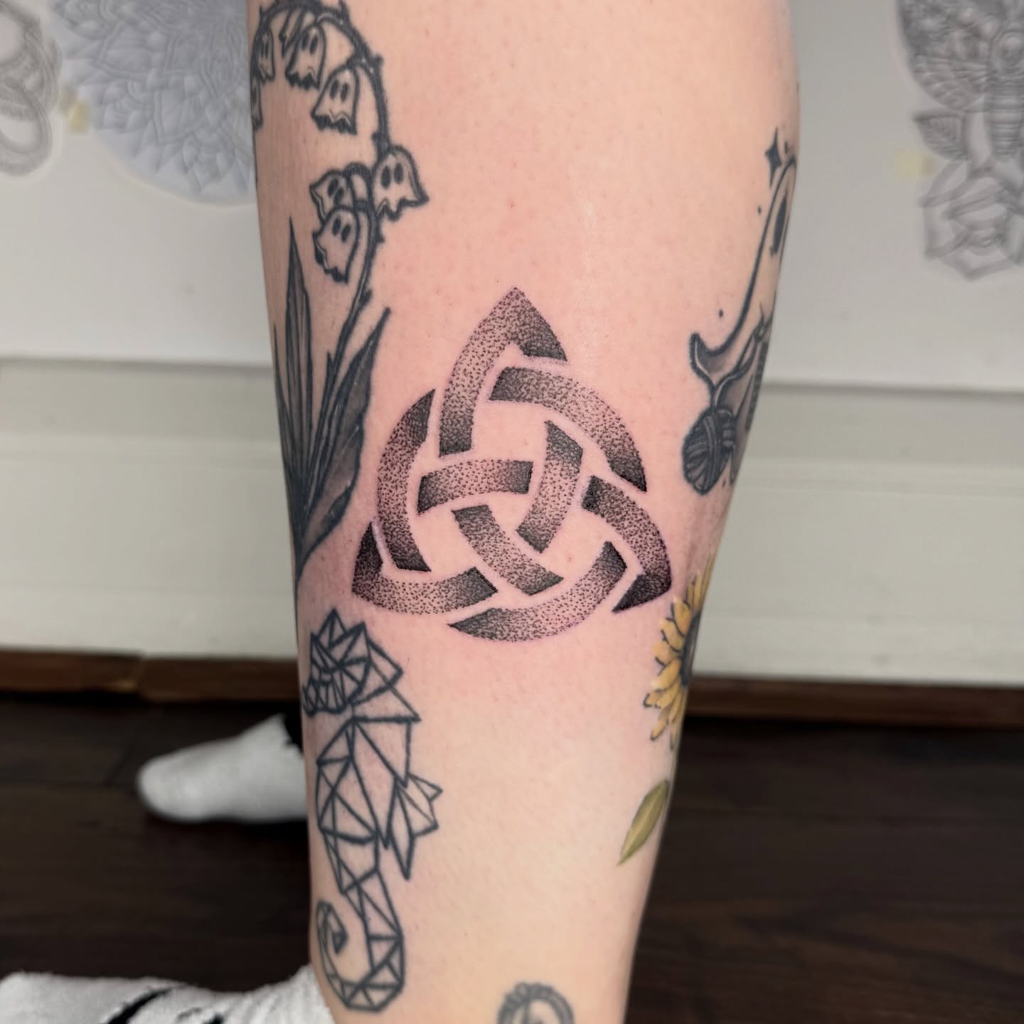Celtic knotwork dotwork tattoo with interlaced bands rendered in stippled dots