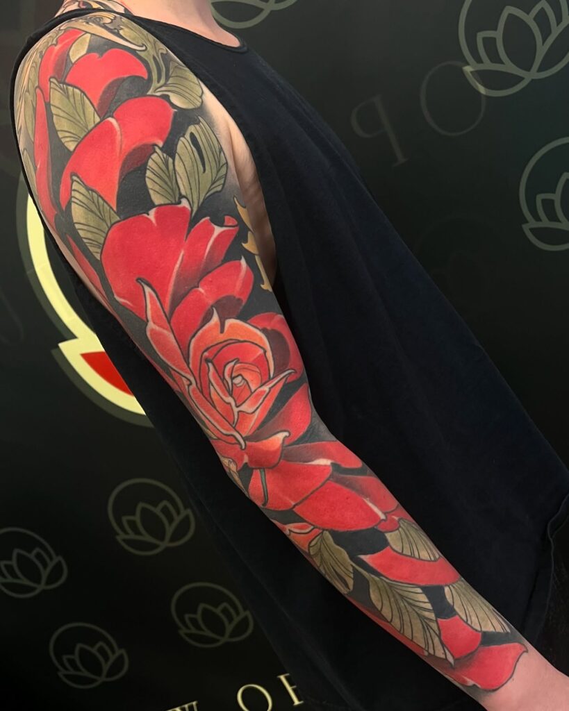 Neo-traditional rose sleeve tattoo with dimensional colour shading and stylised bloom proportions