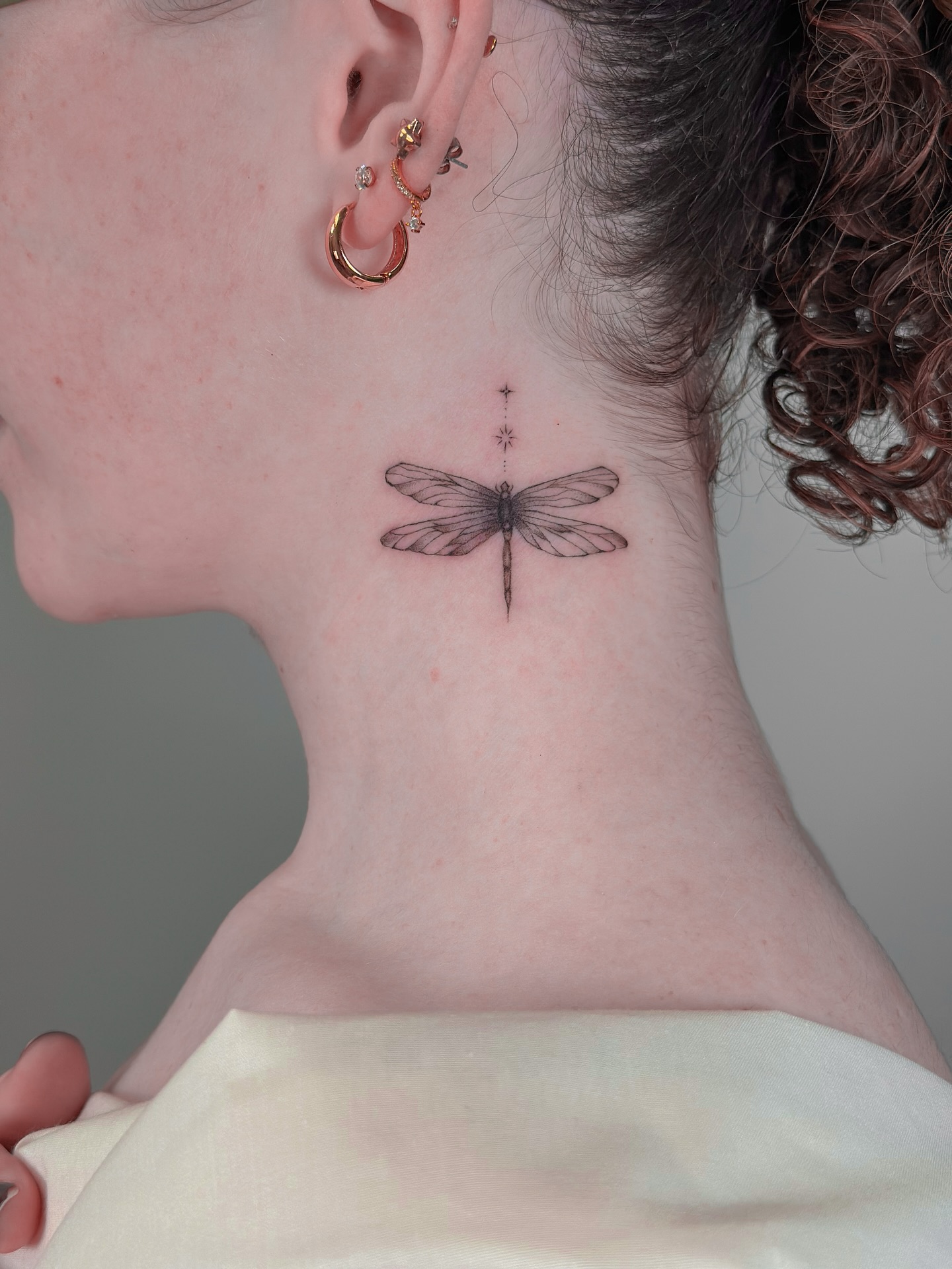 Small dragonfly tattoo with fine line detail