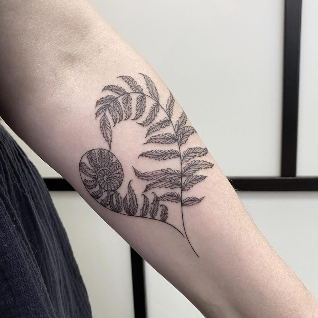 Paired fern tattoos with two mirrored fronds arching on either side of the sternum