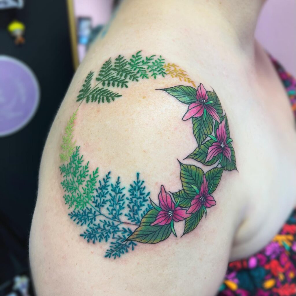Fern wreath tattoo with a ring of fronds framing an area of open skin