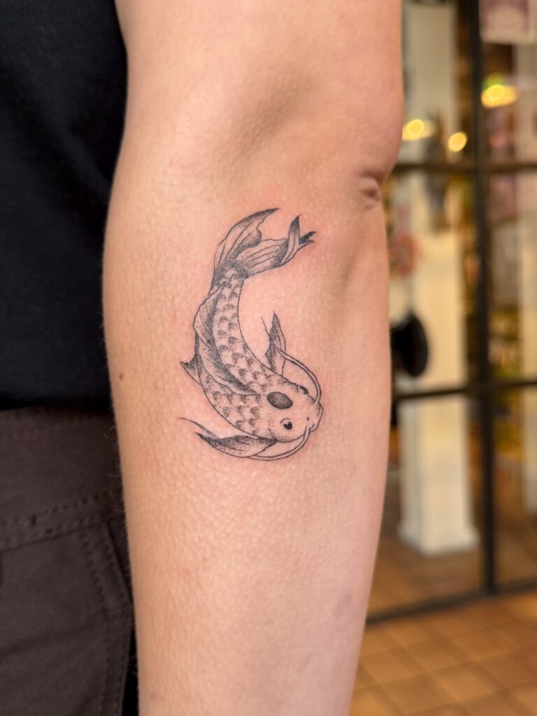 Small koi fish tattoo for men in fine line, a meaningful symbol of perseverance