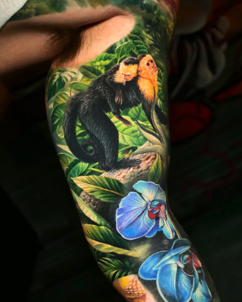 Tropical wildlife colorful sleeve tattoo packed with jungle foliage and brightly coloured birds.