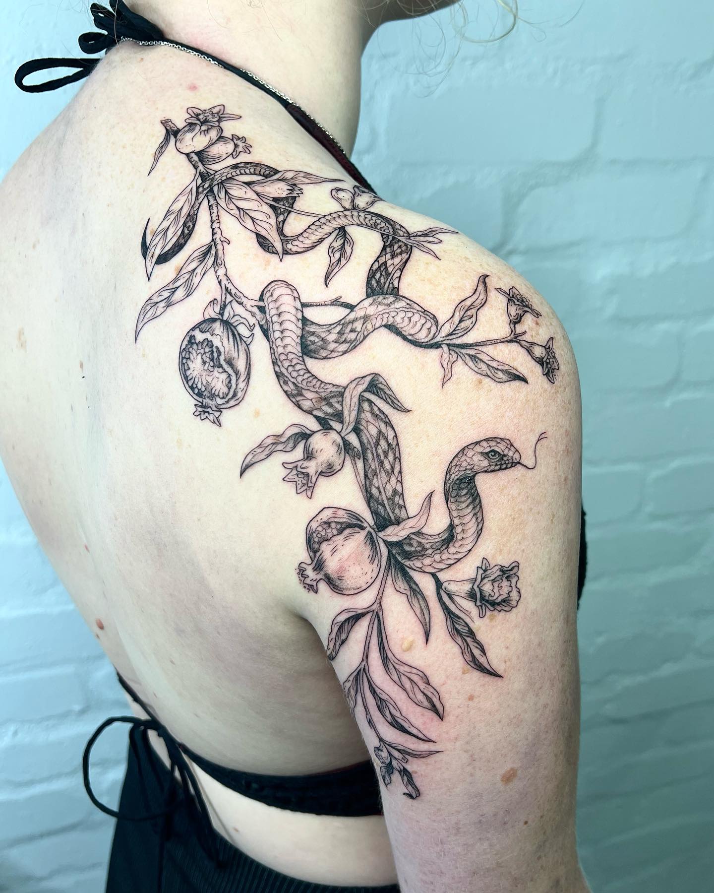 Snake in the garden tattoo for women surrounded by leaves and apples