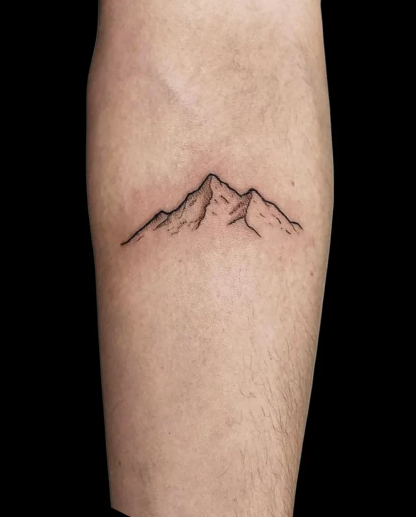 Minimal mountain peak tattoo for men, a simple small meaningful tattoo in black linework