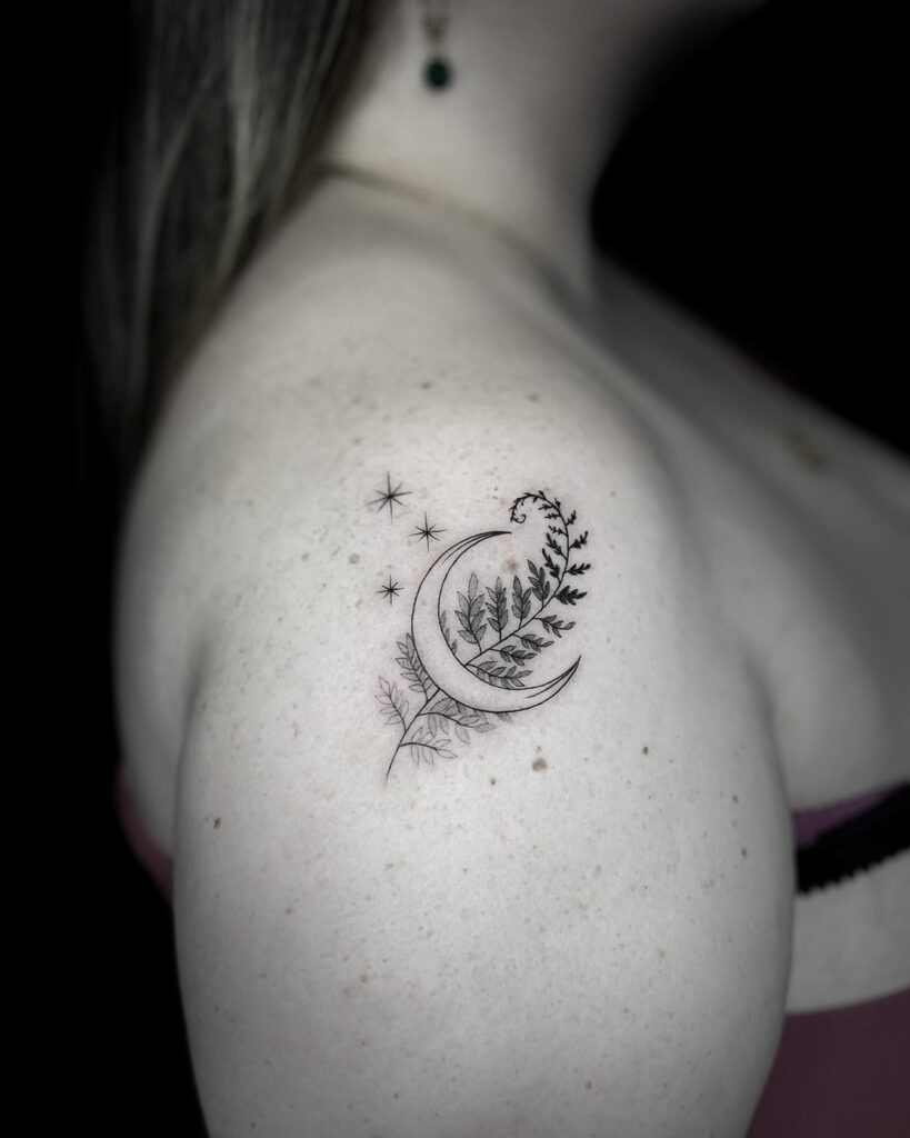Fern and moon tattoo with fronds curling around a crescent moon