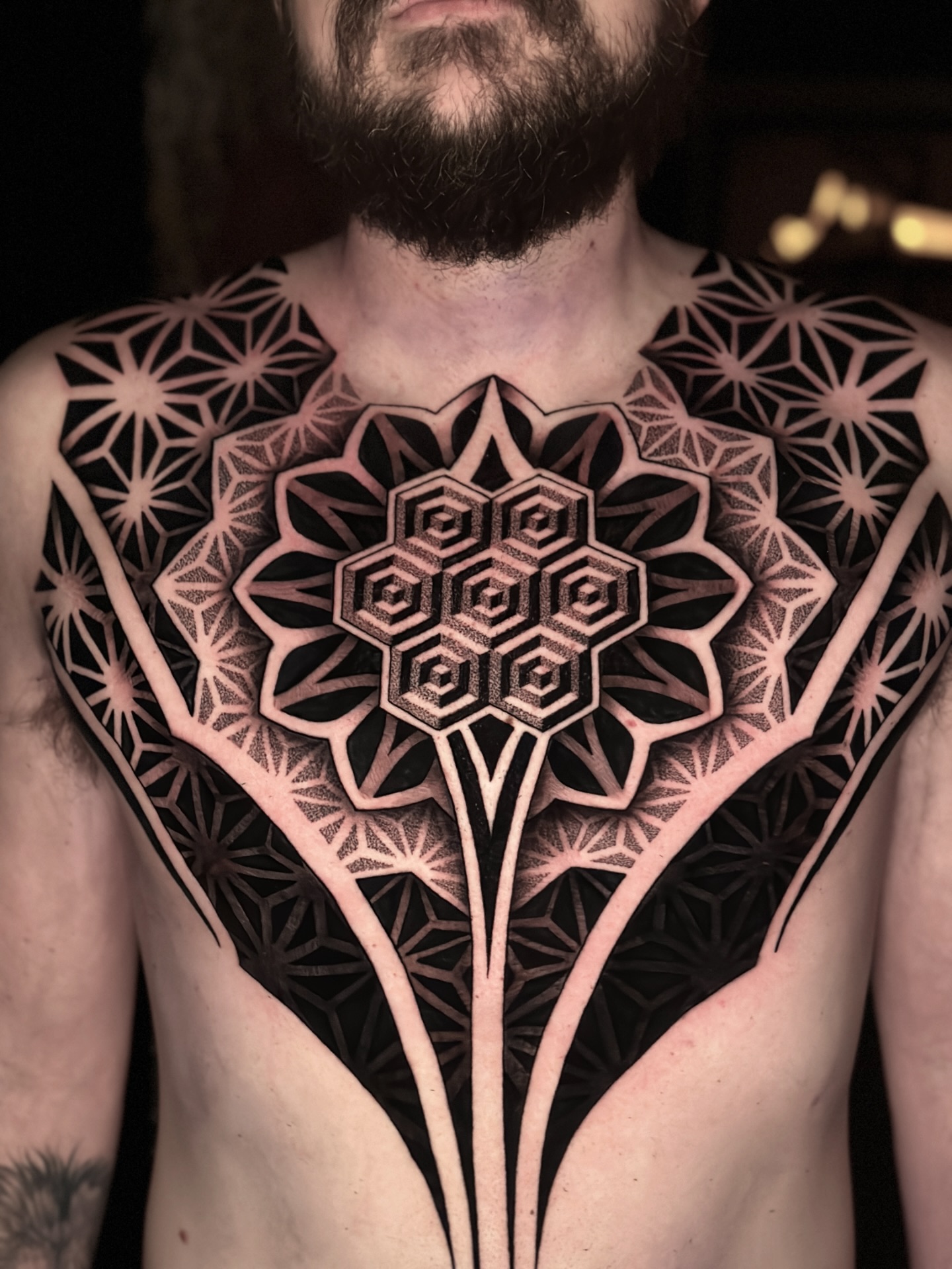 Large chest piece tattoo for men wrapping from the pectoral toward the shoulder