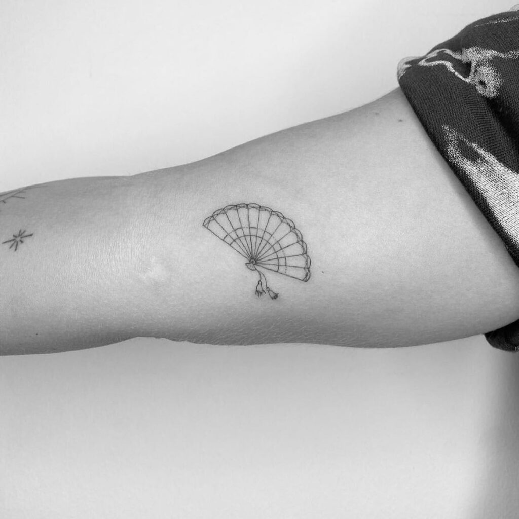 Minimal small tattoo design in black ink, a typical shop-minimum piece