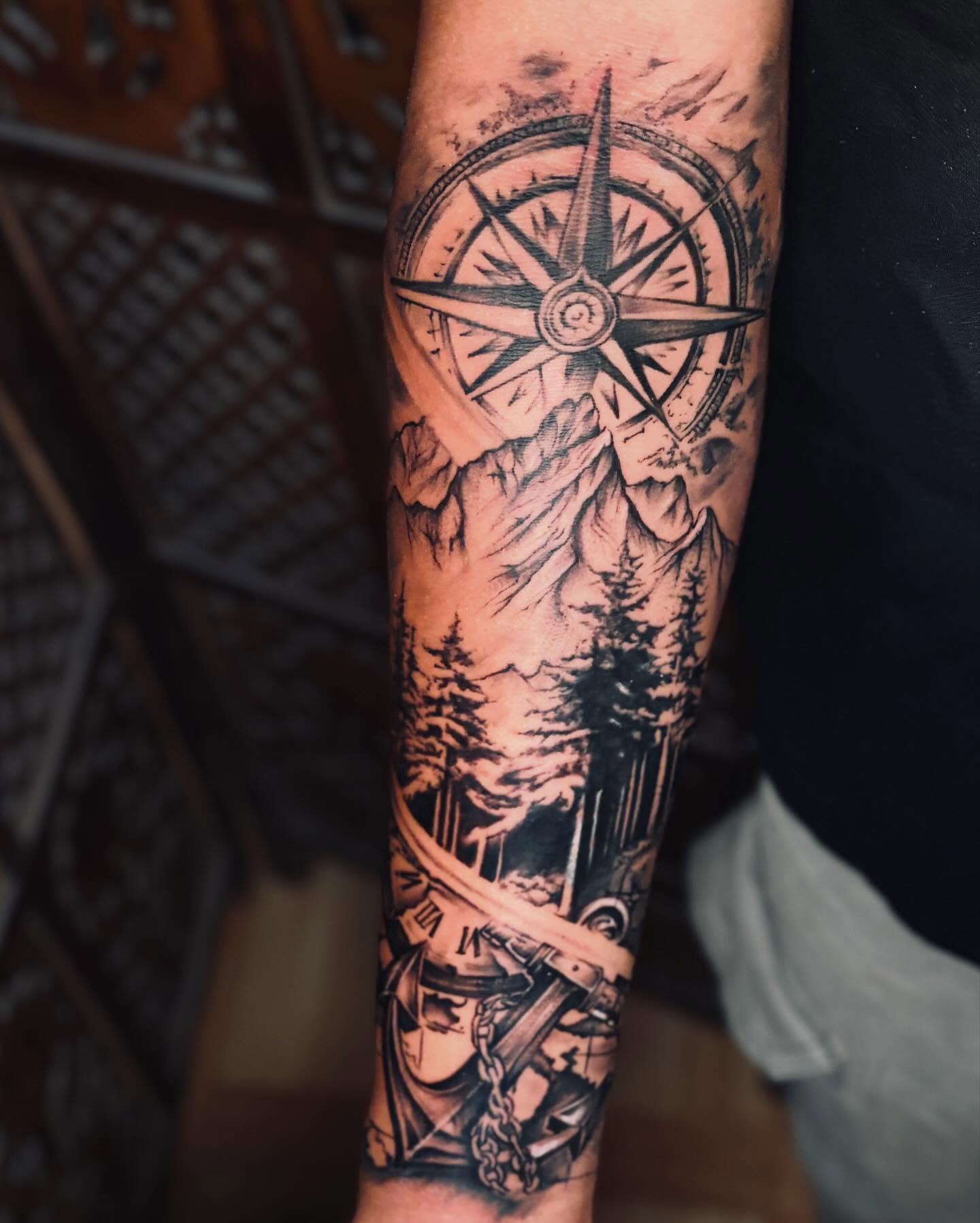 Mountain and compass rose tattoo with a peak set at the north point