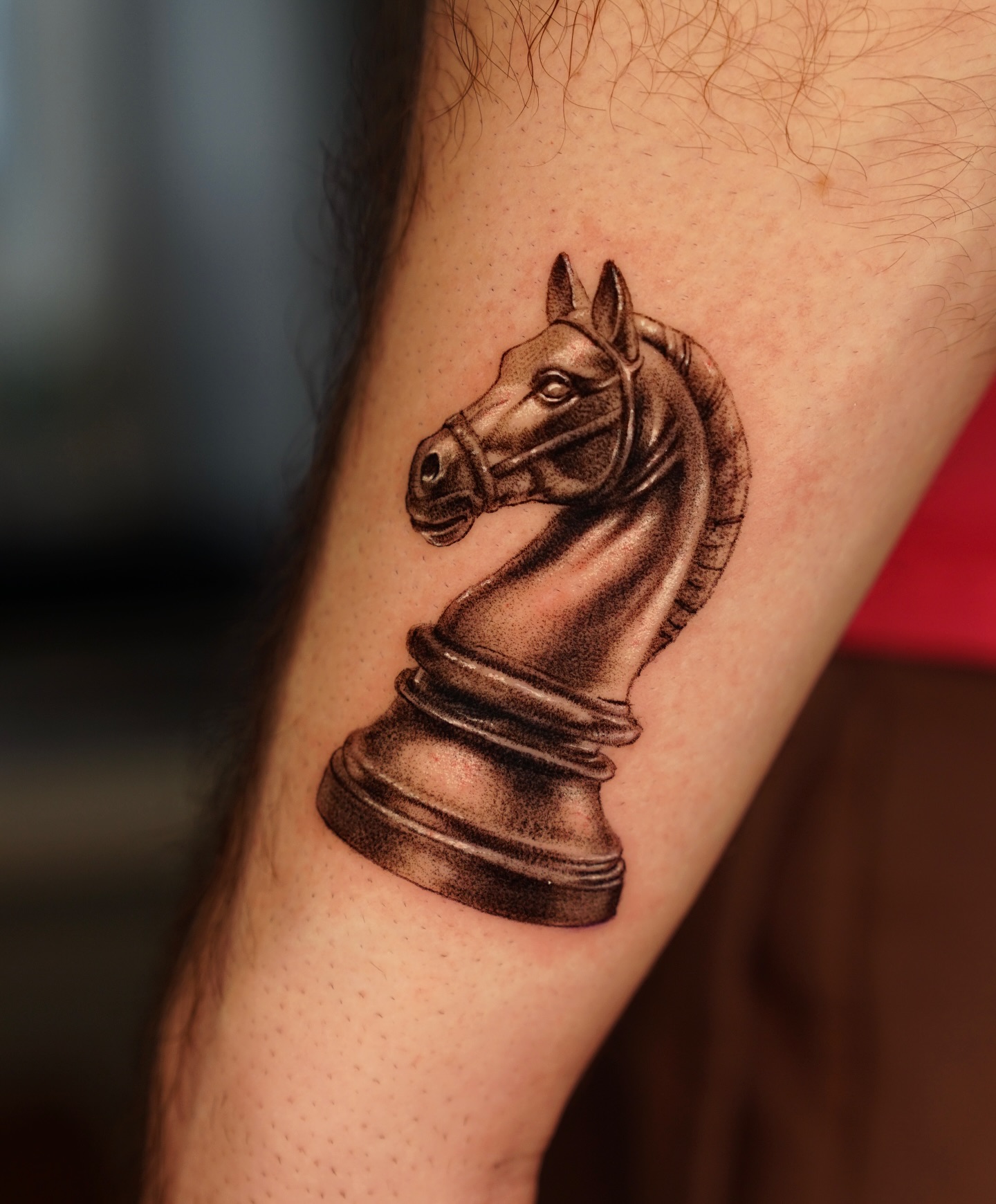 Fine line chess knight tattoo on a man's forearm, a subtle cool tattoo idea for men