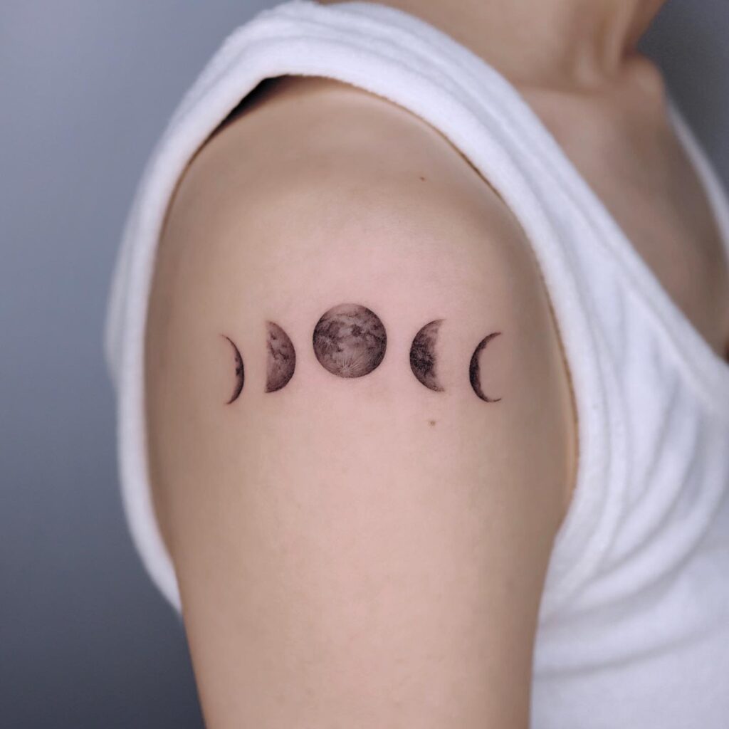 Moon phase space tattoo showing the full lunar cycle in a fine line row