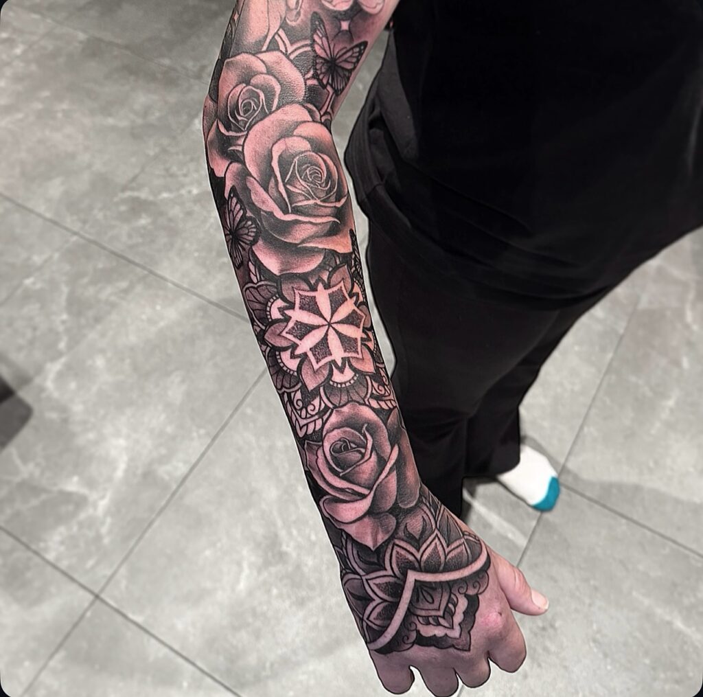 Geometric rose sleeve tattoo combining organic blooms with linework and mandala shapes