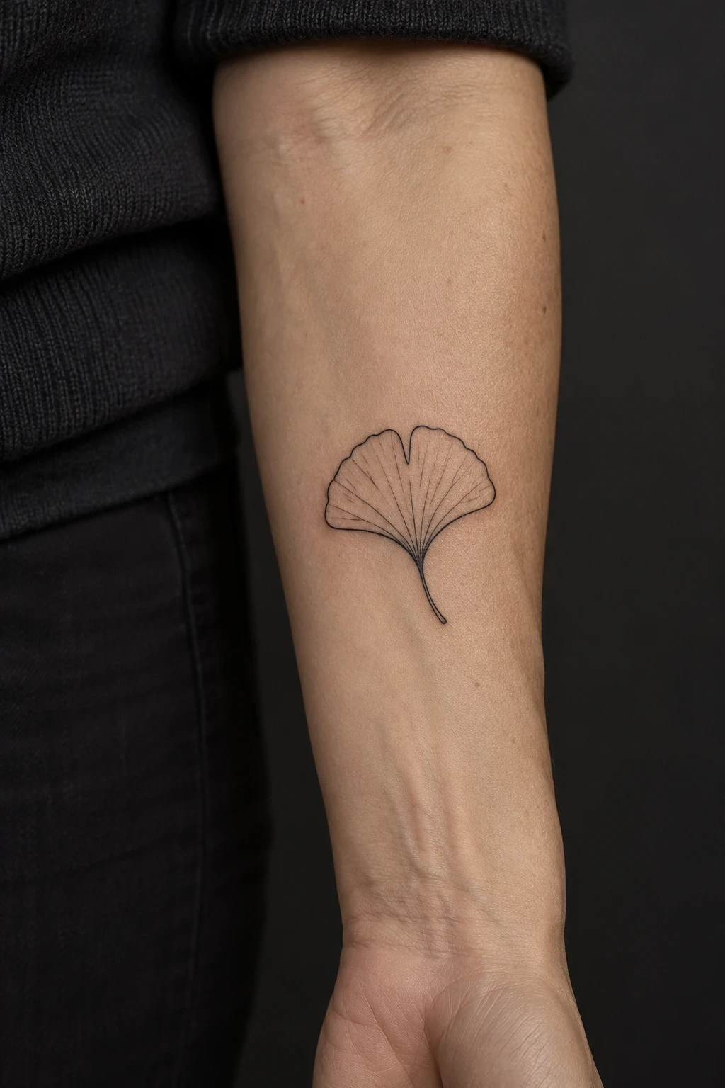 Single ginkgo-leaf tattoo with radiating veins on an inner forearm